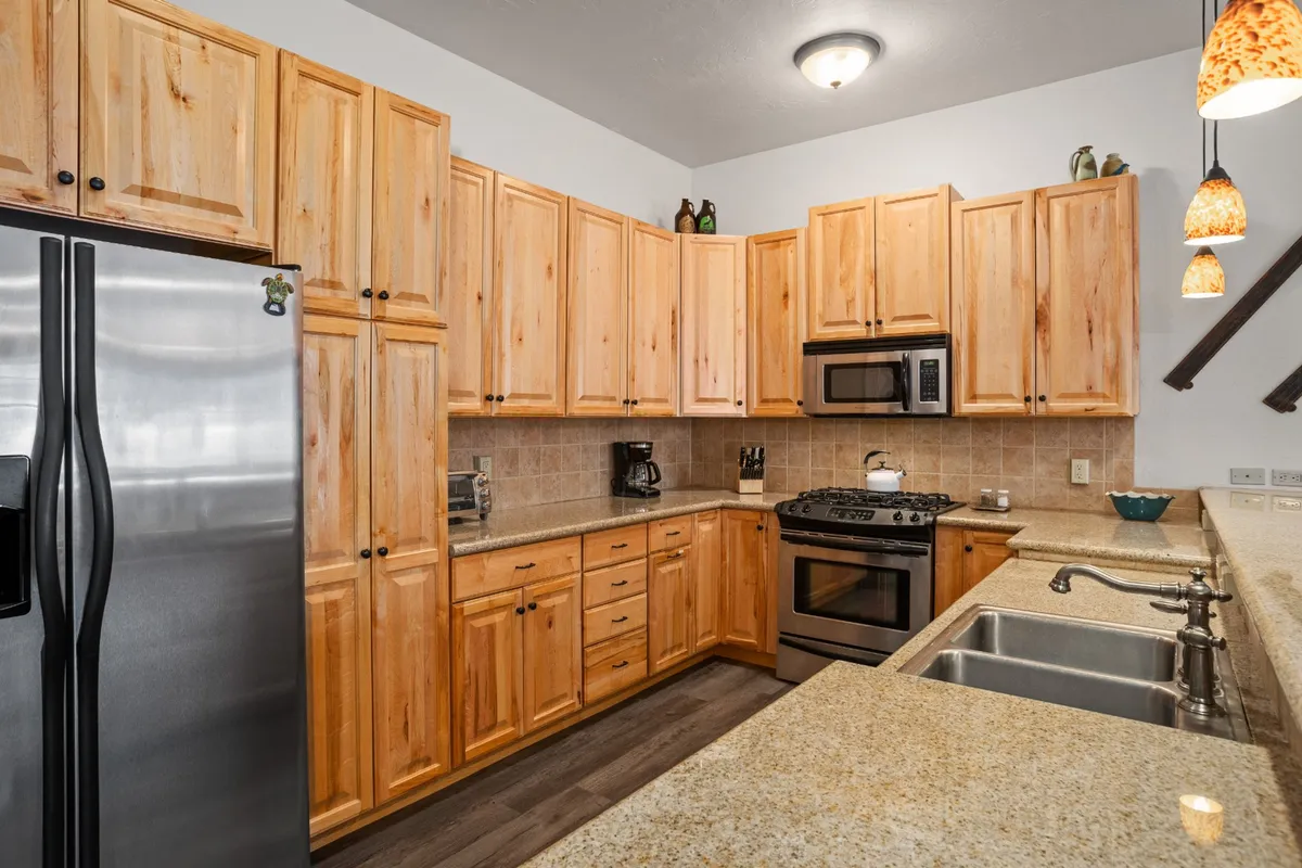 This interior photo highlights a modern kitchen with stainless steel appliances, granite countertops, and warm wooden cabinets. The space is bright and functional, perfectly set up for preparing meals after a day out exploring or for enjoying an easy family dinner together.